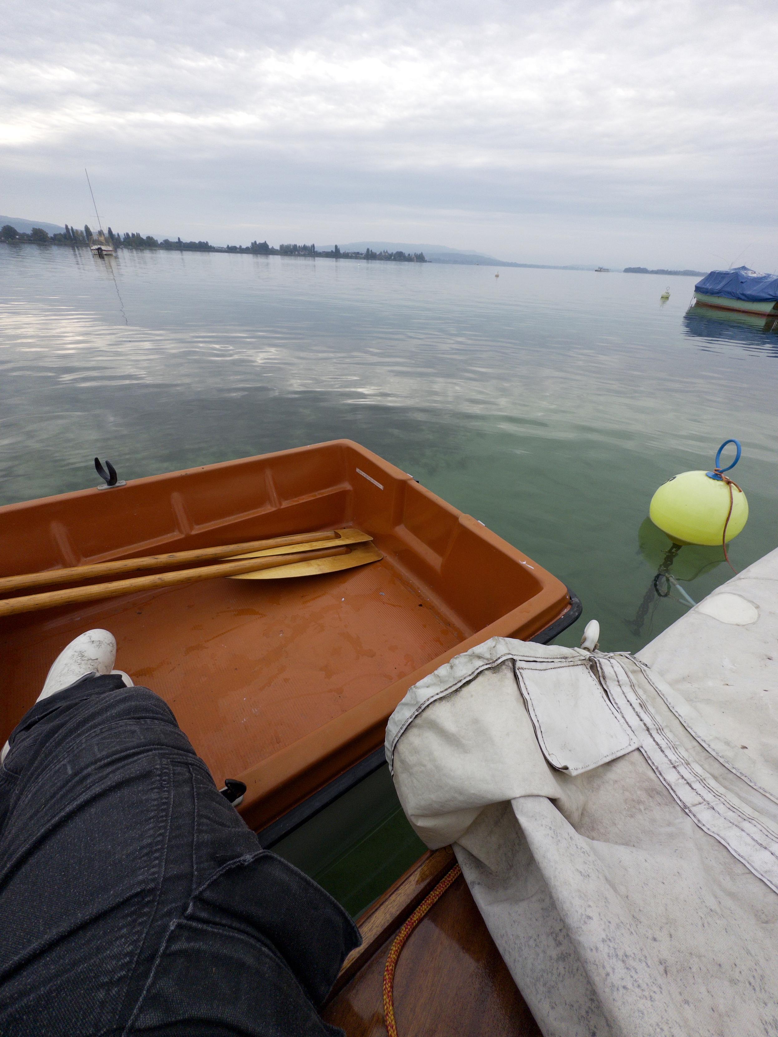 Me, sitting on the deck of the sailboat. Legs in the dinghy. The tarp is open and prepared to be put on again