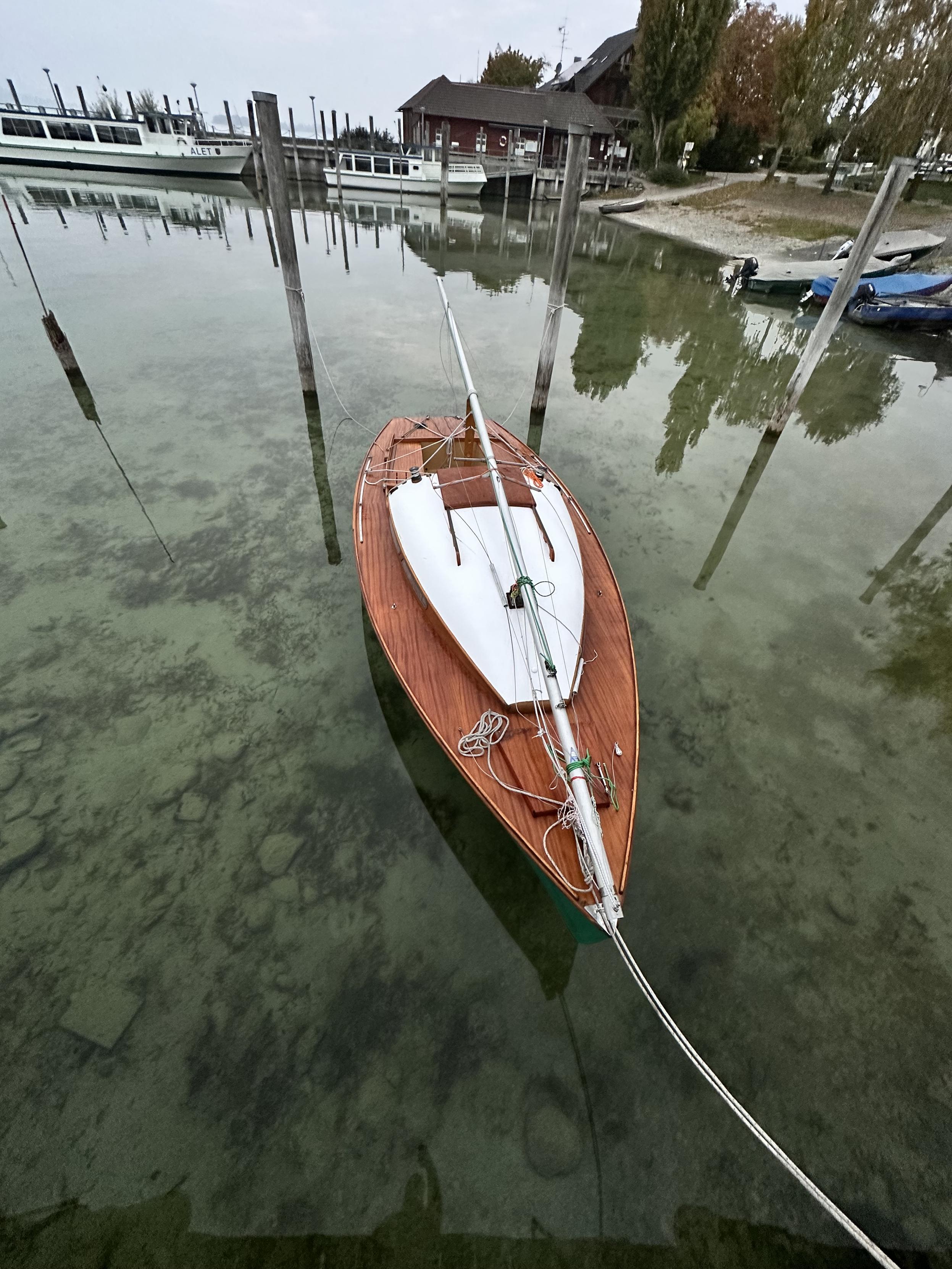Cristal clear water below the boat looks like the boat is sitting on a pane of glass at the jetty ready